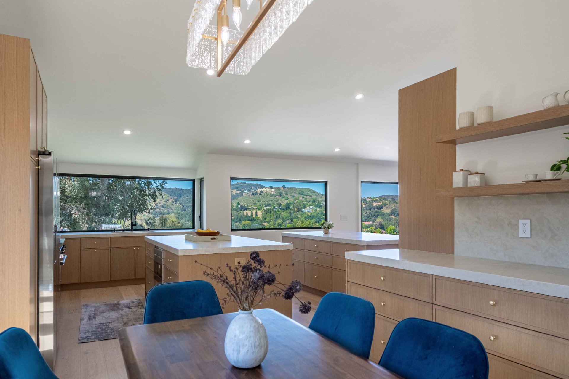 Kitchen and dining with white oak cabinetry and brass chandelier